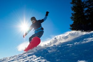 Snowboarder Riding Red Snowboard in the Snowbowl on a Sunny Day
