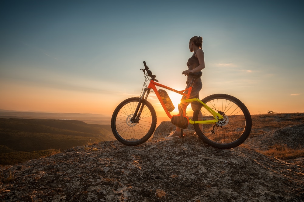 Woman enjoying the view at the top of the best Missoula Mountain Biking Trails at sunset